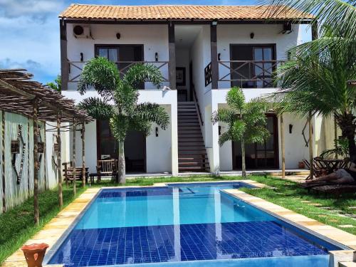 a villa with a swimming pool in front of a house at Casa Vila Prea Jericoacoara é logo ali in Prea