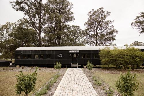 a black train car parked in a field at The Station Hunter Valley in Pokolbin