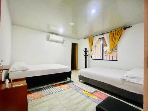 1 dormitorio con 2 camas y ventana en Alojamiento campestre San Miguel, en San José del Guaviare