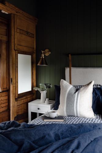 a bedroom with a bed with blue sheets and a window at The Station Hunter Valley in Pokolbin