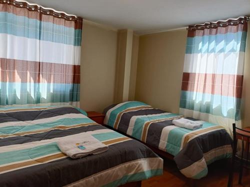 2 Betten in einem Zimmer mit Vorhängen in der Unterkunft Hotel El Gran Valletero in Cotahuasi