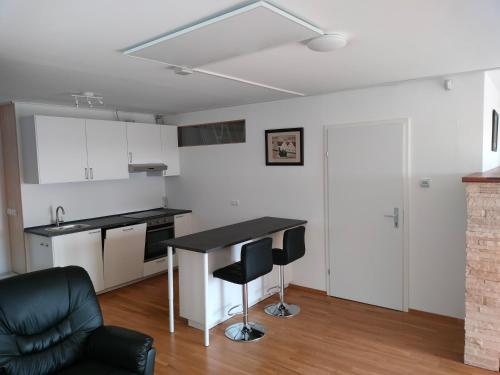 a kitchen with a table and chairs in a room at Self Check-in Self Catering Apartment mit Seeblick und Klimaanlage - Neusiedlersee in Breitenbrunn