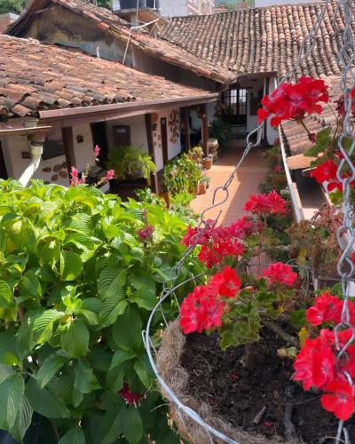 un giardino di fronte a una casa con fiori rossi di Hotel Casa Posada Don Chepe a San Gil