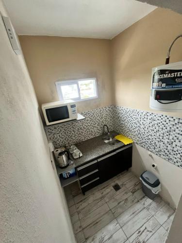 a small kitchen with a sink and a microwave at Tempo Suites in Córdoba