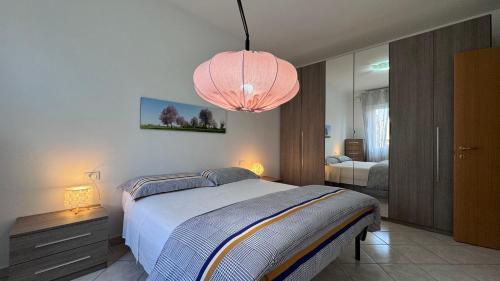 1 dormitorio con 1 cama grande y 1 lámpara de color rosa en Casa Zia Màpò en Ferrara