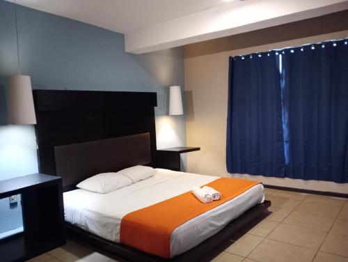 a bedroom with a large bed with an orange blanket at Hotel BLVD in Playa del Carmen