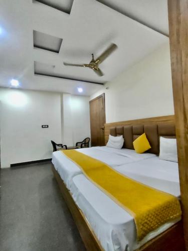 Hotel Wonder Premium Family Stay في ماثورا: غرفة نوم بسرير كبير بسقف