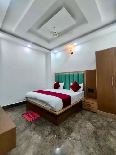 Hotel Wonder Premium Family Stay في ماثورا: غرفة نوم بسرير كبير ومخدات حمراء
