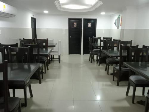 ein Esszimmer mit Holztischen und -stühlen in der Unterkunft Hotel Suite Imperial 72 in Barranquilla