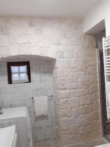 baño con pared de piedra y lavamanos en Holiday Home Cosimo en Locorotondo