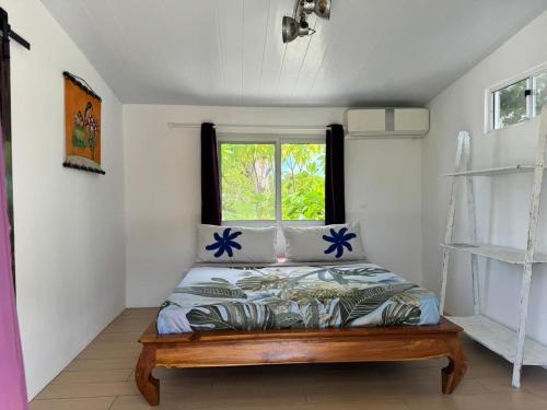 a small bedroom with a bed with a window at Rangiroa Cottage in Avatoru