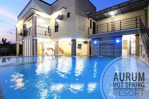 a villa with a swimming pool at night at Aurum Hot Spring Resort in Los Baños