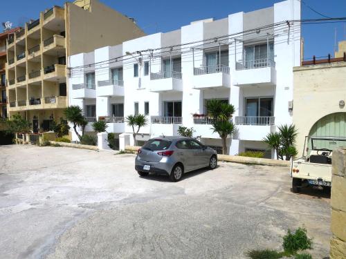 um carro estacionado num parque de estacionamento em frente a um edifício em 3 Balconies South Views Special Bedroom 5 mins to beach em Mellieħa