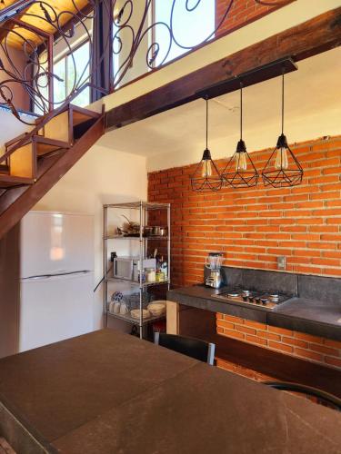 a kitchen with a white refrigerator and a brick wall at Villa Lakota By Natut Huasca in Huasca de Ocampo
