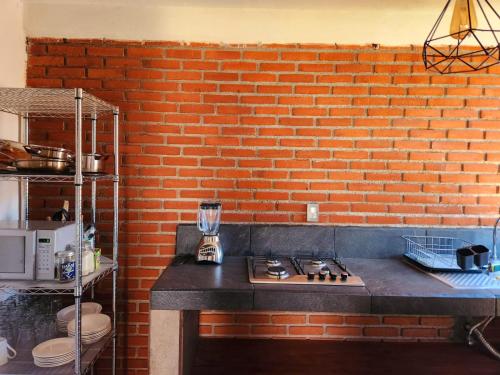 a kitchen with a brick wall and a counter top at Villa Lakota By Natut Huasca in Huasca de Ocampo
