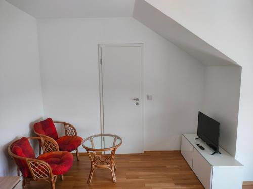 a living room with two chairs and a television at Doppelzimmer mit Seeblick - Neusiedlersee in Breitenbrunn