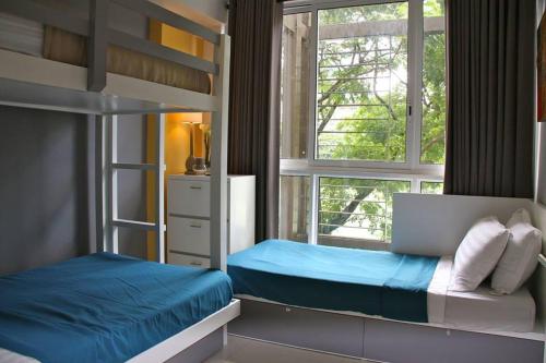 a bedroom with a bunk bed and a window at Condominium at Carola in Nasugbu