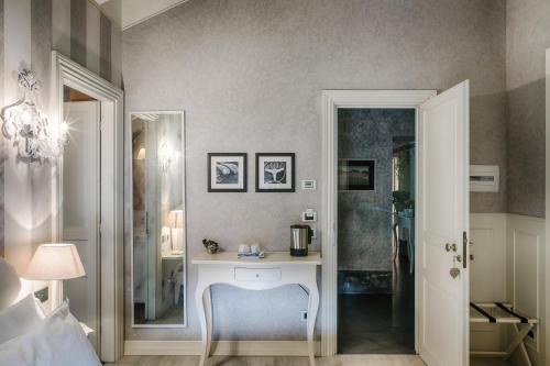 a bedroom with a table and a blue chair at Relais Villa Vittoria in Laglio