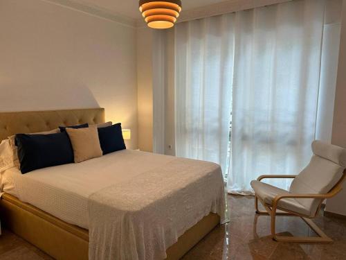 a bedroom with a bed and a chair and a window at REGIDOR Cartagena in Cartagena