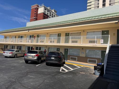 two cars parked in a parking lot in front of a building at The Boards AC in Atlantic City