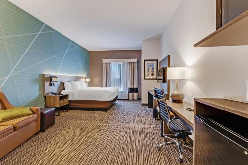 a hotel room with a bed and a desk at Comfort Suites Murfreesboro in Murfreesboro