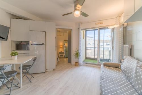une cuisine et un salon avec un canapé et une table dans l'établissement Appt t2 cabine clim parking privée vu mer, à Sète