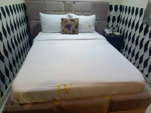 una gran cama blanca con dos gatos sentados en ella en Ikad Hotel and Suite, en Lagos