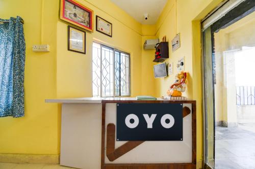 un panneau ovo sur un mur jaune dans une pièce dans l'établissement SPOT ON Hotel Sunshine Lodging, à Āsansol