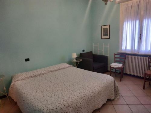 ein Schlafzimmer mit einem Bett und einem Stuhl in der Unterkunft B&B Alla Villa in Parma