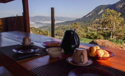 a table with plates of food on it with a view at Cabana do Camelo in São Bento do Sapucaí
