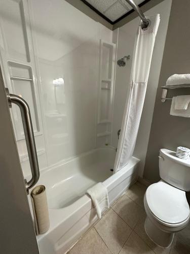 a bathroom with a tub and a toilet and a sink at Le Voyageur Inn in Mattawa