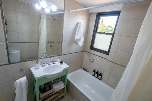 ein Badezimmer mit einem Waschbecken, einem WC, einer Badewanne und einem Waschbecken in der Unterkunft Andes Vista tu lugar en Mendoza in Godoy Cruz