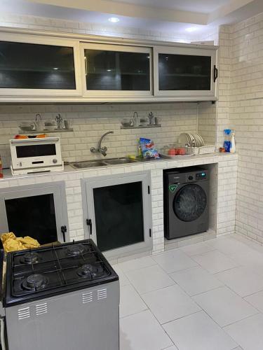 Il comprend une cuisine équipée d'une cuisinière et d'un lave-vaisselle. dans l'établissement Villas meublé yoff, à Dakar