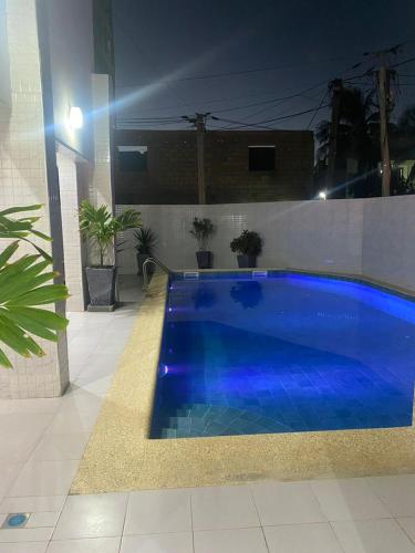 達喀爾的住宿－Villas meublé yoff，夜间在院子里的大型蓝色游泳池