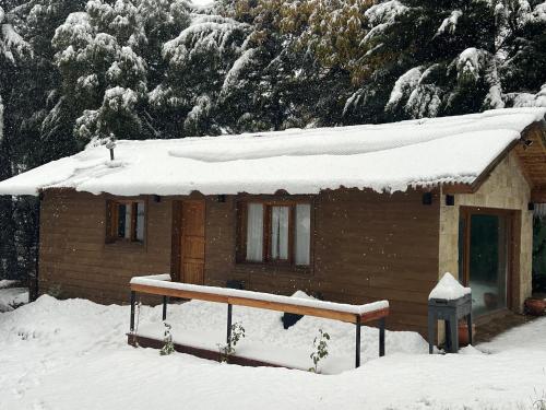a small cabin with snow on the roof of it at Casa con vista al lago in San Carlos de Bariloche
