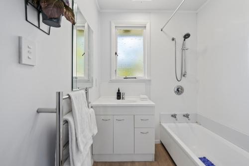 uma casa de banho branca com uma banheira e um lavatório em Tui Paradise - Havelock North em Havelock North