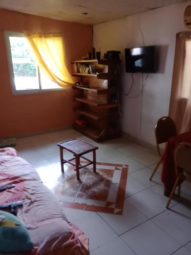 sala de estar con mesa y TV en Taca Tucan Hostel, en Playa Blanca