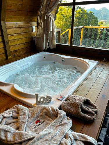 une baignoire jacuzzi dans une chambre avec fenêtre dans l'établissement Refúgio Suiço em Vargem Alta, à Vargem Alta