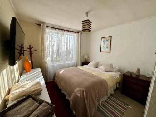 una camera con letto e finestra di Casa amoblada en Nos a Santiago