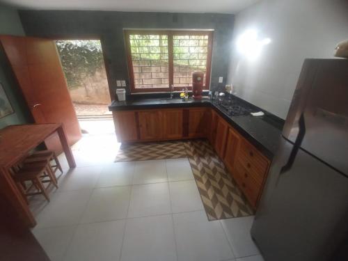 eine Küche mit einer schwarzen Arbeitsplatte und einem Kühlschrank in der Unterkunft Casa da Floresta in Lavras