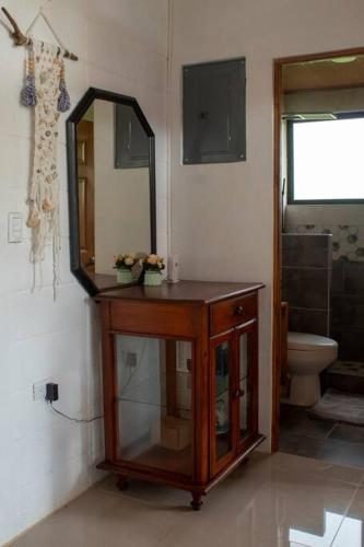 a bathroom with a vanity and a mirror and a toilet at Pura Vida Beach House in San Buenaventura
