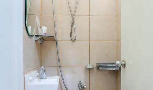 a bathroom with a shower with a sink and a mirror at iPark Hotel by Hiverooms in Cebu City