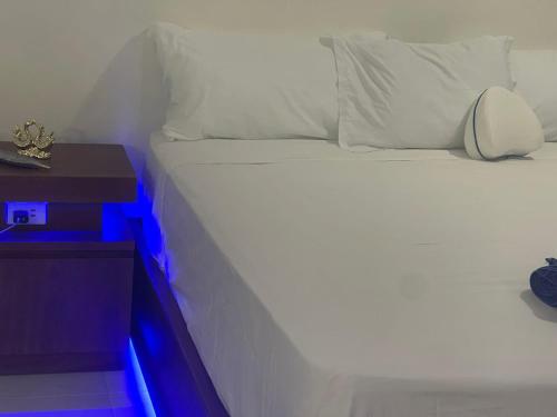 a white bed with a night stand next to it at Eco casa sosua in Sosúa