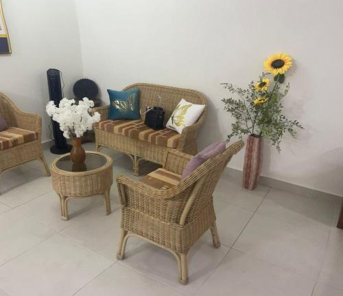 a living room with chairs and a couch and flowers at Eco casa sosua in Sosúa