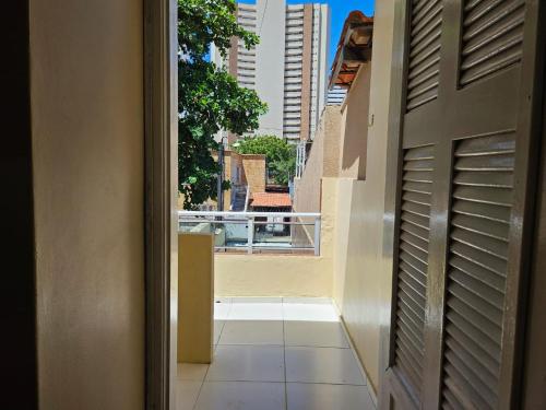 an open door to a balcony with a view of a building at POUSADA MAR DE IRACEMA in Fortaleza