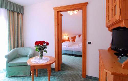 a hotel room with a vase of flowers on a table at Santeshotel in Anterselva di Mezzo
