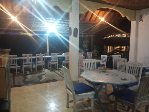 - une salle à manger avec une table, des chaises et des lumières dans l'établissement Sunrise Cafe Bungalows, à Amed