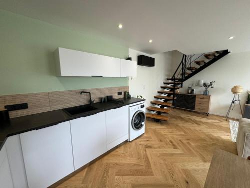 a kitchen with a sink and a washing machine at Maison bretonne en pierre rénovée in Plédran