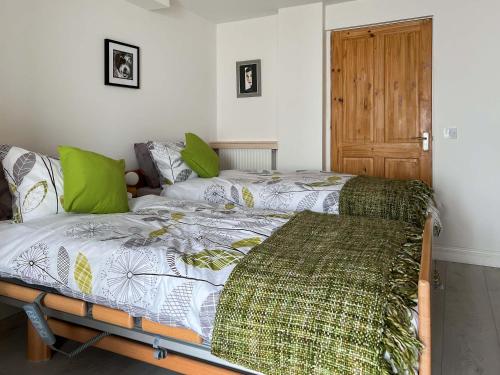 um quarto com 2 camas e uma porta de madeira em Estuary Retreat em Llanelli