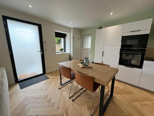 a kitchen and dining room with a table and chairs at Maison bretonne en pierre rénovée in Plédran
